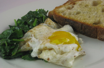Photo of Runny Eggs on Wilted Greens
